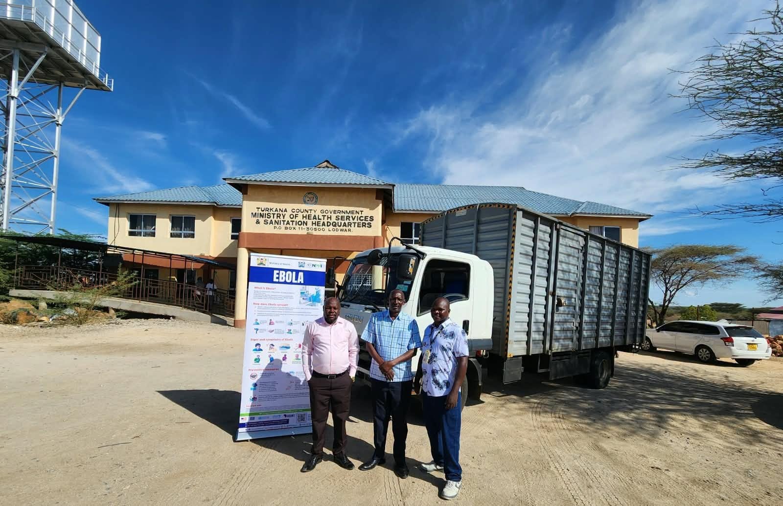 Turkana County health officials stand beside a truck during the handover of Ebola preparedness supplies in Lodwar.