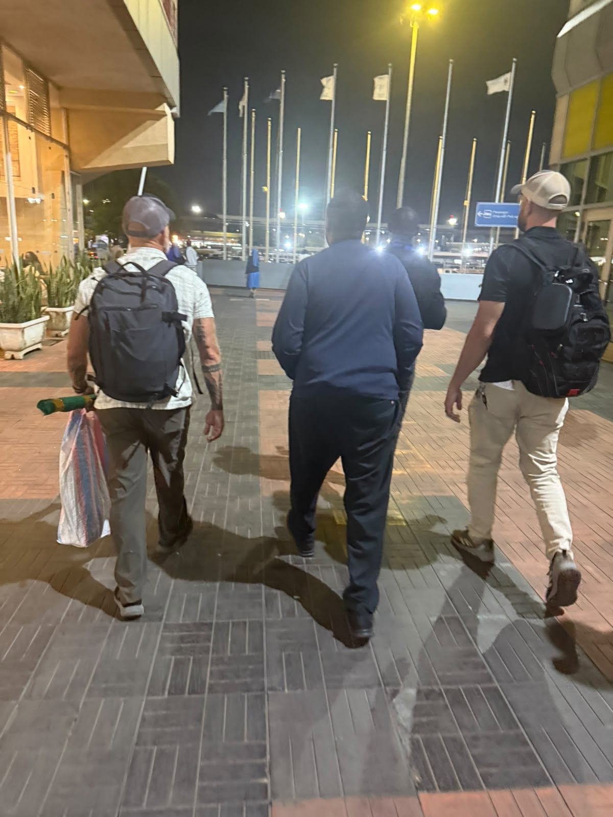 Men walk outside an airport terminal at night in a photograph supplied with a report on Sancho Kibutu’s extradition to the United States.